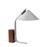 The aluminum arc and shade of the desk lamp seen from behind