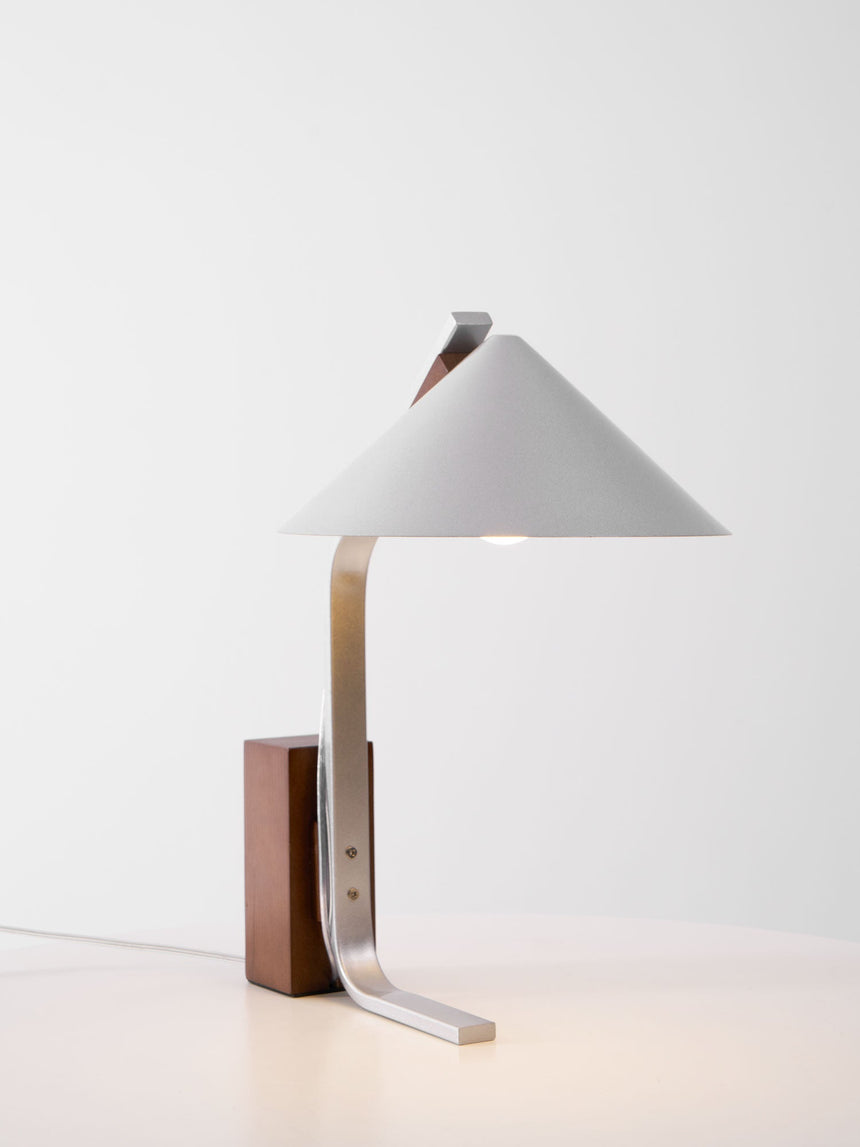 Minimalist desk lamp with a white cone shade seen from the front
