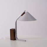 Full view of the minimalist desk lamp against a plain pale ground