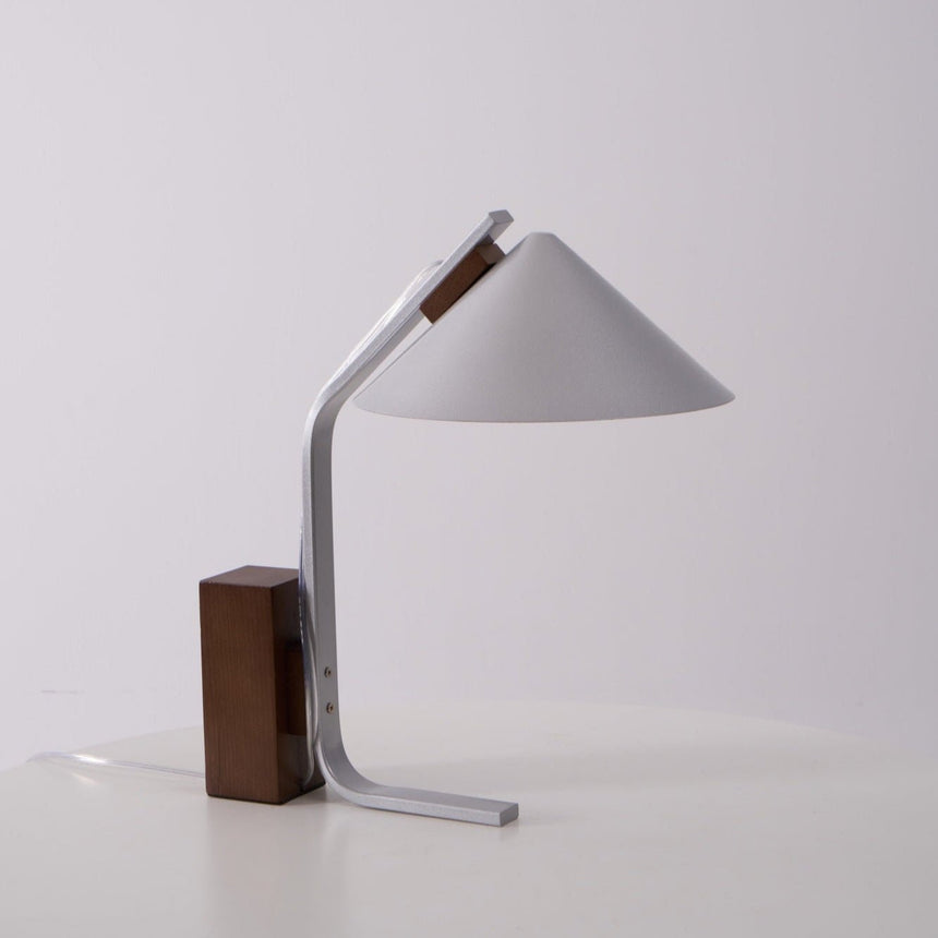 Full view of the minimalist desk lamp against a plain pale ground