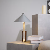 Minimalist desk lamp on a concrete cube seen from across the room