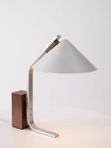 Minimalist desk lamp seen from the side, the arc curve in profile
