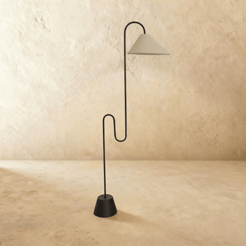 The same black stem with a white cone shade, the stepped base resting on the floor