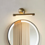 Bronze bar lit over a round mirror reflecting a curtain, the glow filling the glass