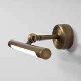 The bronze bar turned down on its joint, seen at an angle against a pale wall