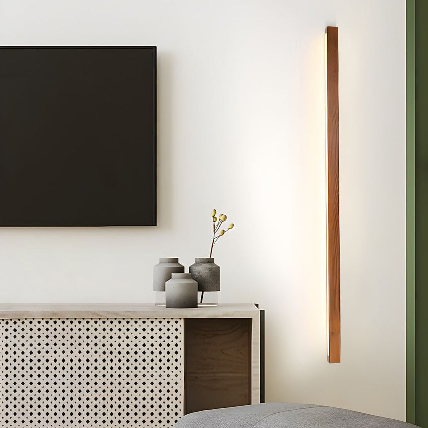 The bar mounted vertically beside a sideboard, lighting the wall