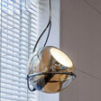 The mirrored globe tilted in its ring in front of a white window blind