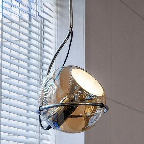 The mirrored globe tilted in its ring in front of a white window blind