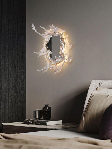 The mirrored light lit on a dark bedroom wall above the bed