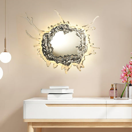 The mirrored light glowing above a white console with books and flowers