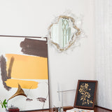 The mirrored light above a table with a framed print and a lamp