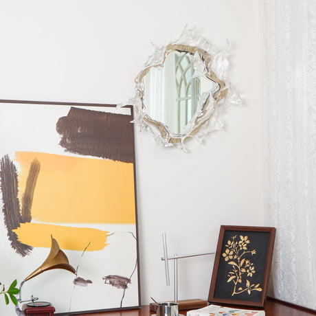 The mirrored light above a table with a framed print and a lamp