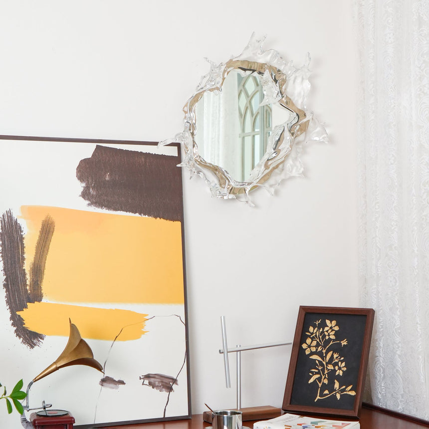 The mirrored light above a table with a framed print and a lamp