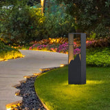 One lit at a lawn border beside a curving paved path and flowers