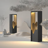 Two lit in a raked white sand garden beside a pale stone and a tree