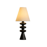 Black rippled base table lamp lit, the shade glowing warm
