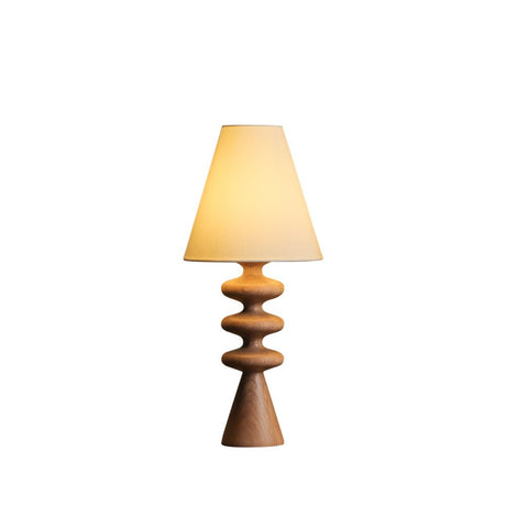 Rippled base table lamp in light wood against a plain white ground