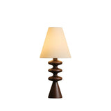 Rippled base table lamp in a walnut tone against a plain ground