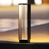 The tall body lit on a terrace coping with a dark garden behind it
