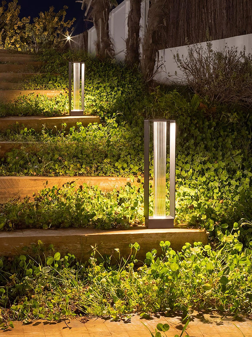 The tall body lit beside lit timber steps and low garden planting
