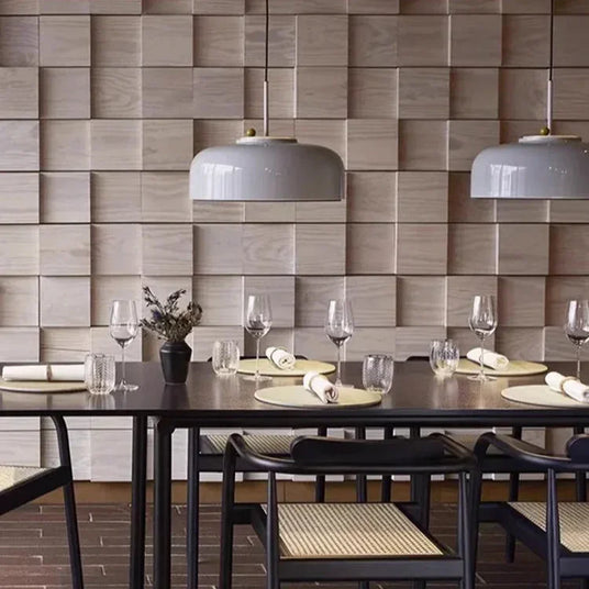 Two gray honeycomb pendants above a long dining table set for a meal
