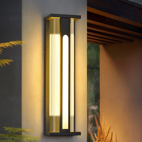 The light on a wall under timber eaves with ornamental grasses below