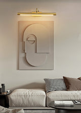 Gold bar lit above a sculpted panel over a bed with striped cushions