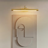 Gold bar lit over a pale sculpted wall panel, the beam washing down its face