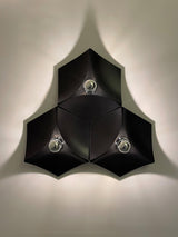 Three black lights fitted together in a triangle, lit