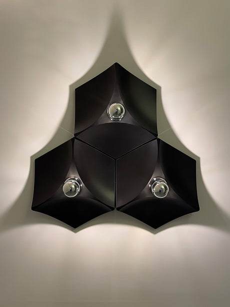 Three black lights fitted together in a triangle, lit