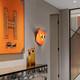 The orange light in a hallway beside a framed print and a console