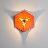 The orange light lit, casting a three point shadow on the wall