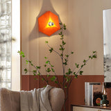 The orange light lit above a sofa and a potted plant in a living room