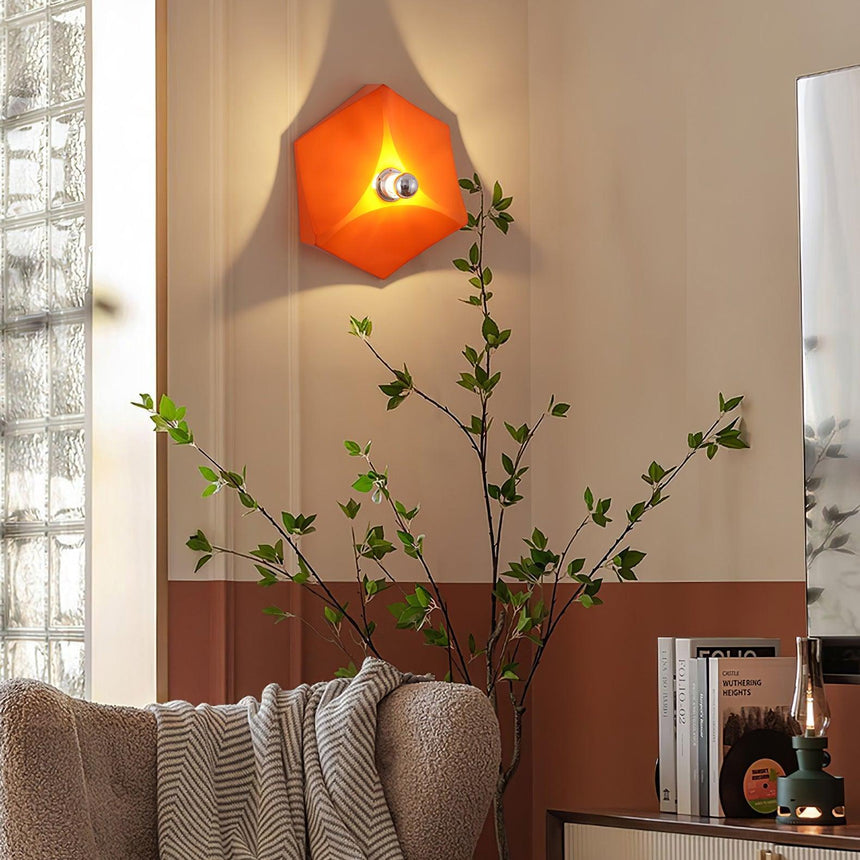 The orange light lit above a sofa and a potted plant in a living room