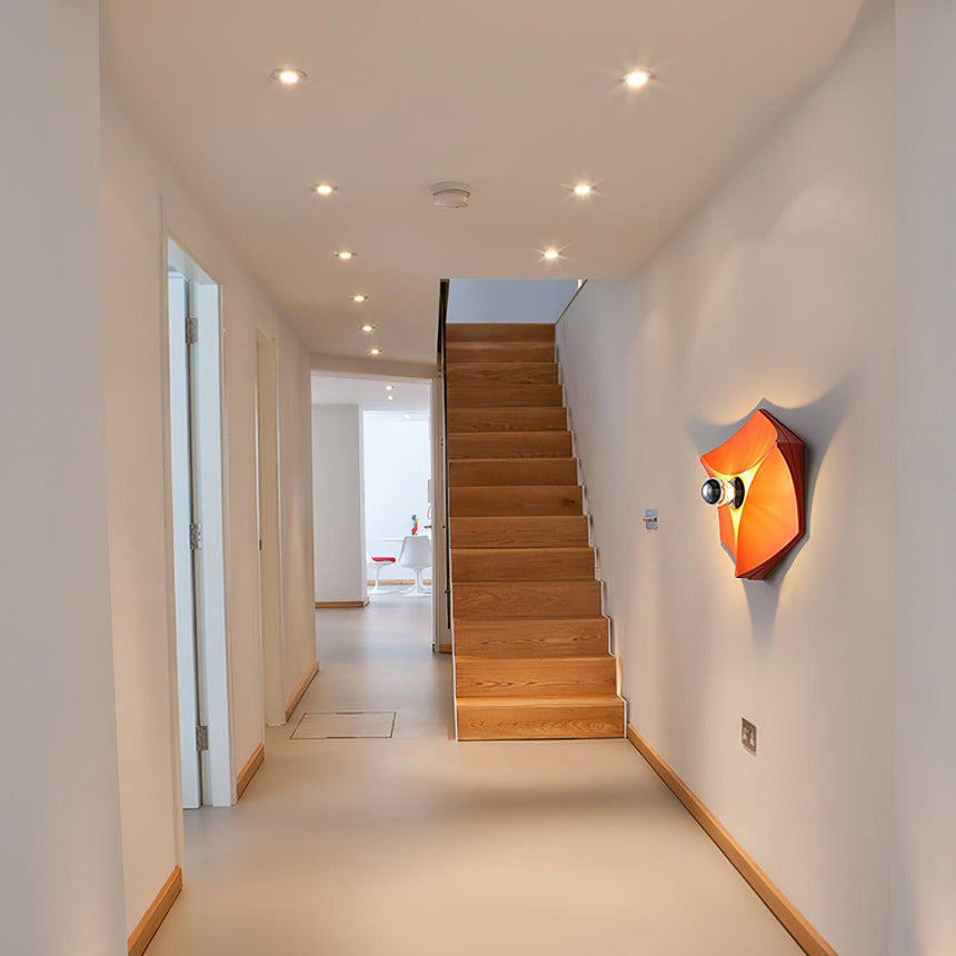 The orange light lit in a long hallway leading to a wood staircase