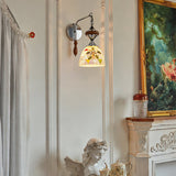 The shell mosaic version beside a painting and a white sculpture on a mantel