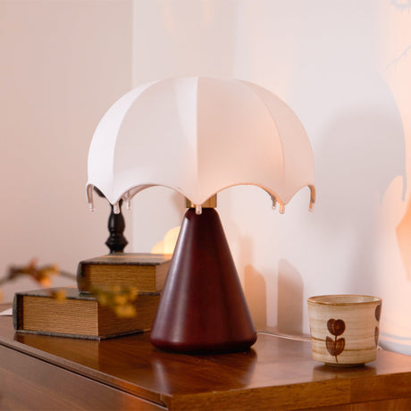 Nightstand lamp lit close on a dresser, the silk ribs visible