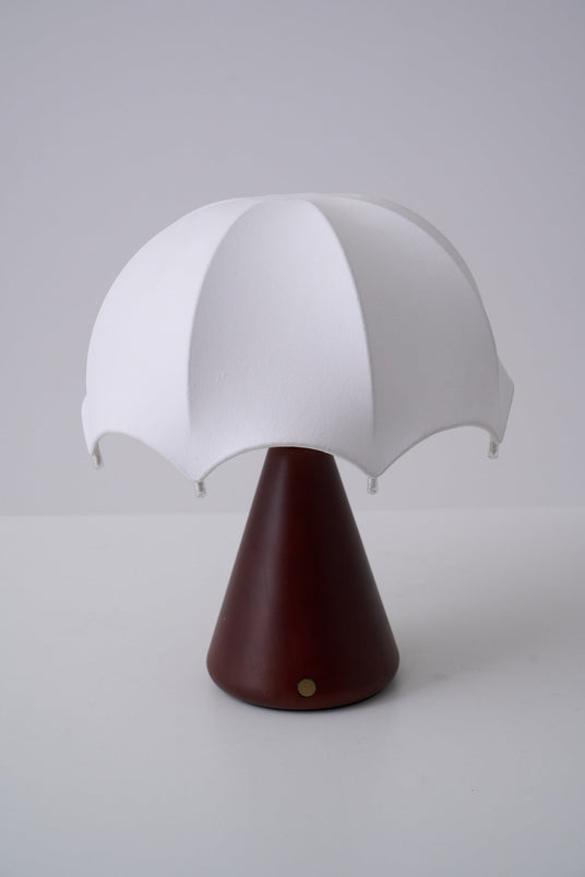 Close view of the scalloped hem of the silk shade above the cone