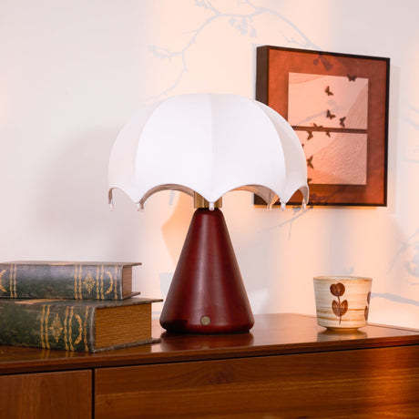 Nightstand lamp unlit on a dresser beside a framed print