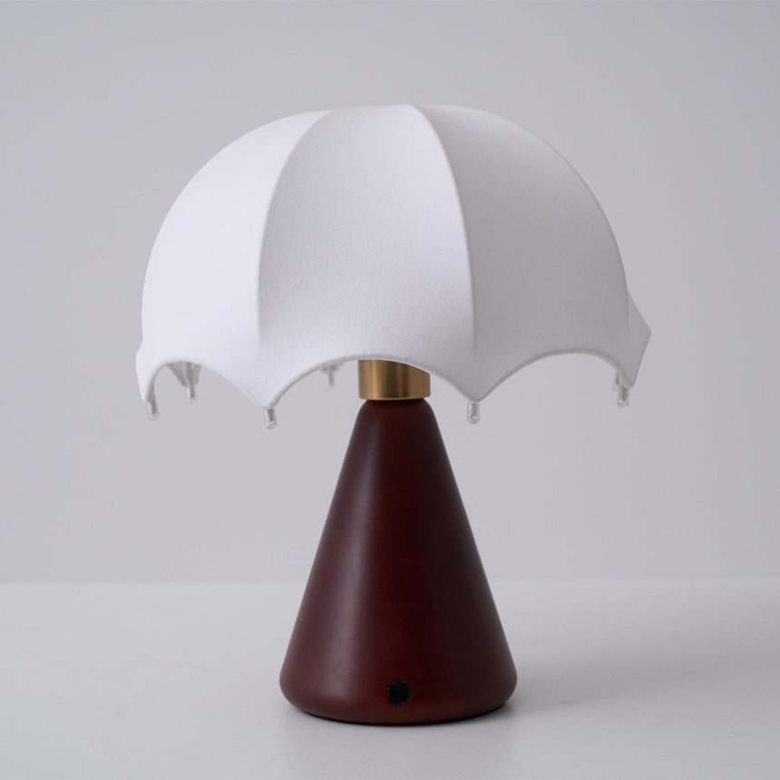 Nightstand lamp unlit against a plain gray ground, seen front on