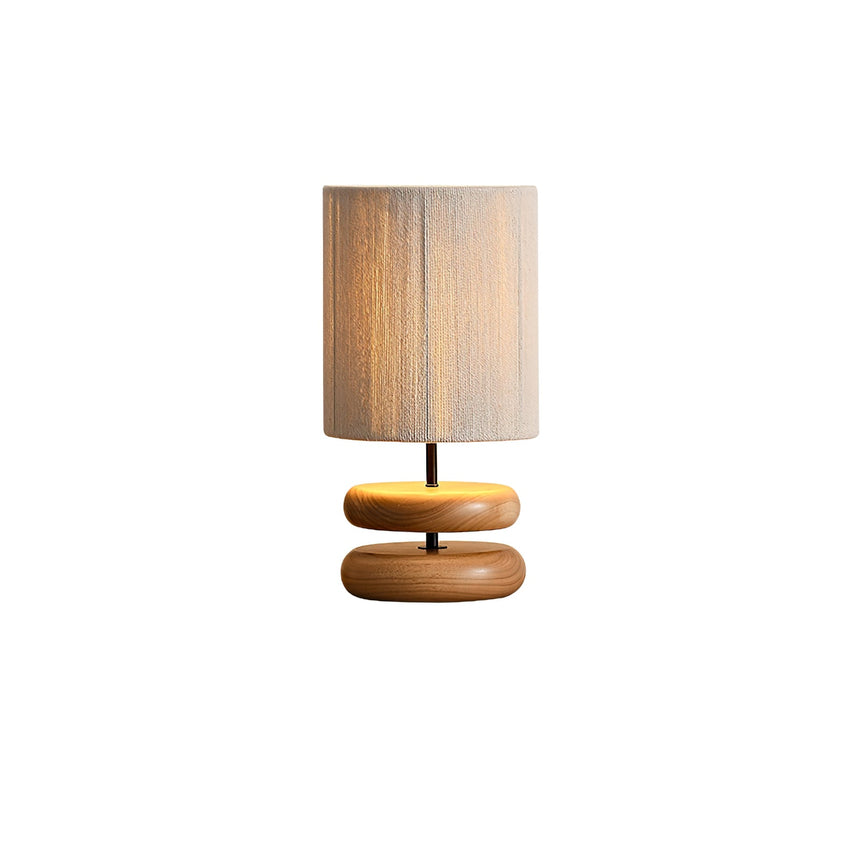 Nightstand table lamp seen straight on, the stacked pebbles and rope shade
