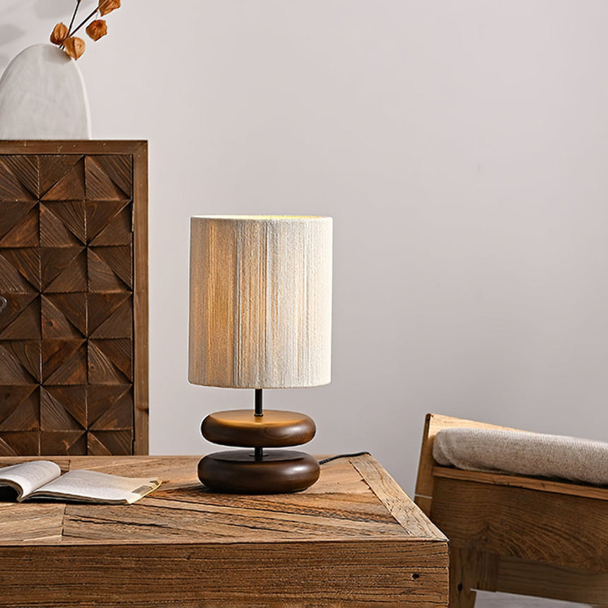 Black pebble nightstand table lamp on a wooden table