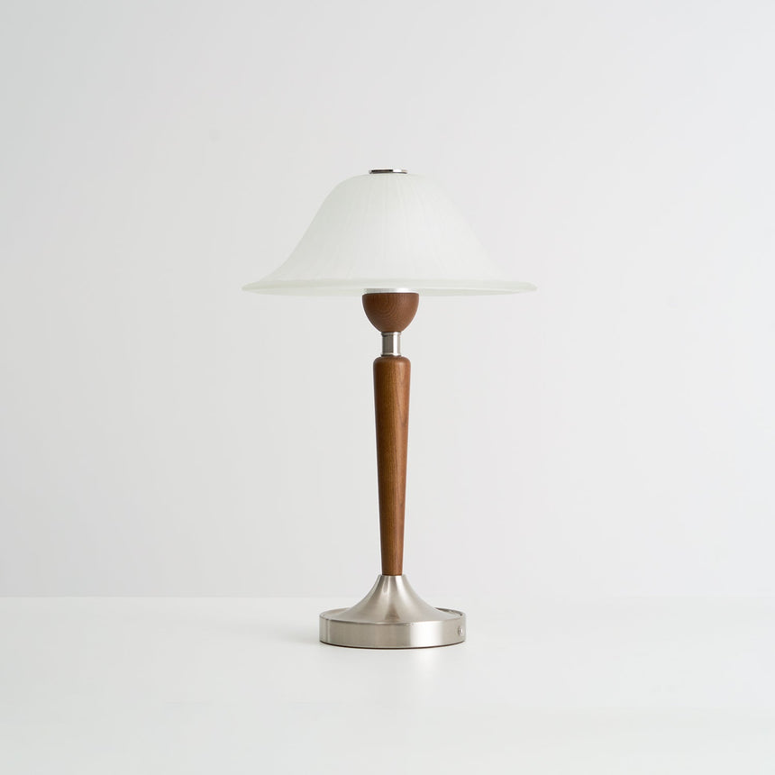 Nightstand table lamp seen from the side against a plain pale ground