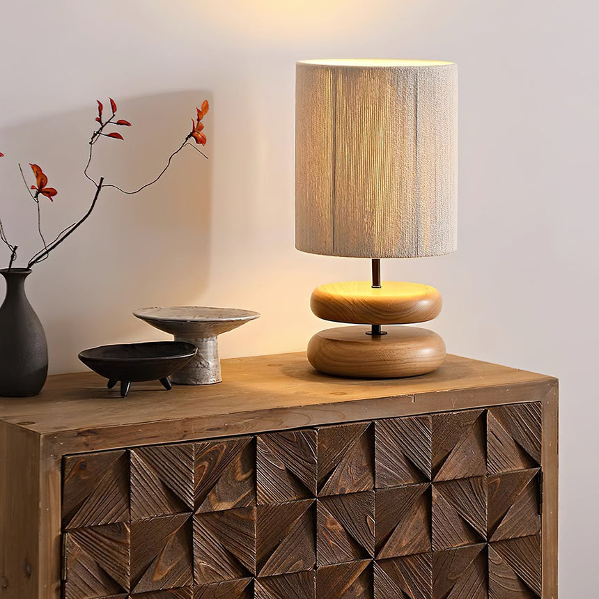 Black and wood nightstand table lamps lit together on a sideboard