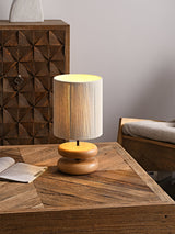 Wood pebble nightstand table lamp lit on a wooden table