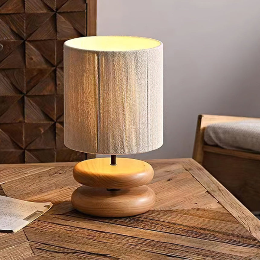 Nightstand table lamp on a wooden table in front of a carved wall panel