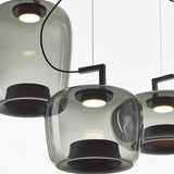 Cluster of tinted glass shades seen from below in a dark room