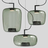 Three green glass shades at different heights above a pale floor