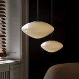Two opal pebble shades lit at different heights in a dark room
