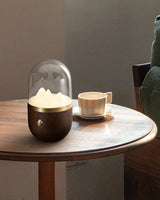 Nursery table lamp lit on a round table beside a cup of coffee